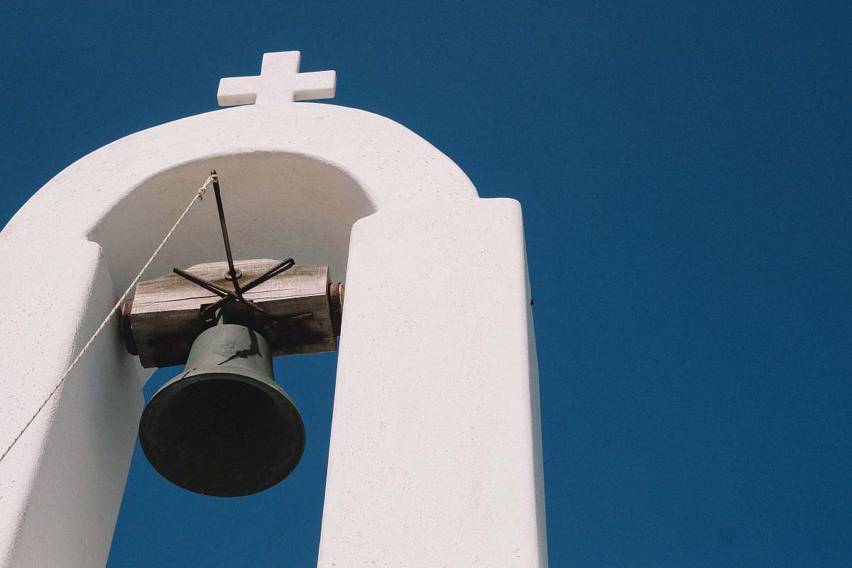bell tower gray bell hanging on white arch building